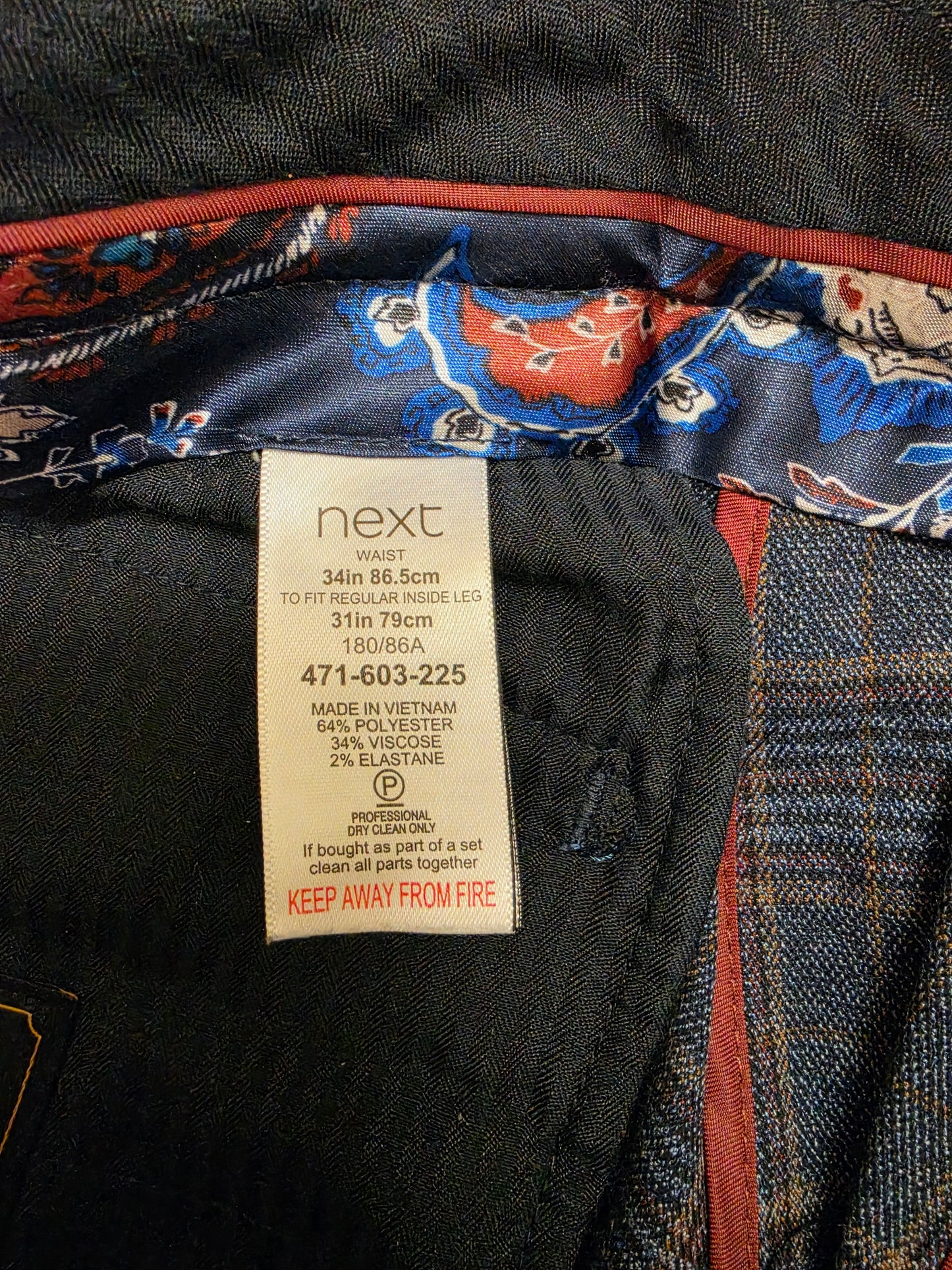 Close-up of a next size label  for a pair of check trousers
