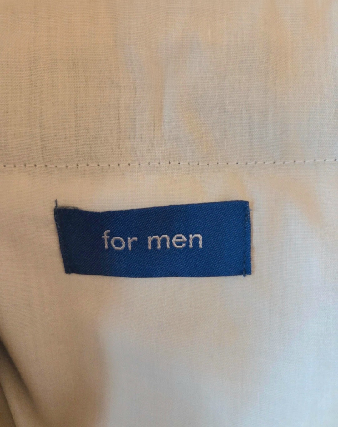 Blue label on beige fabric with 'for men' text