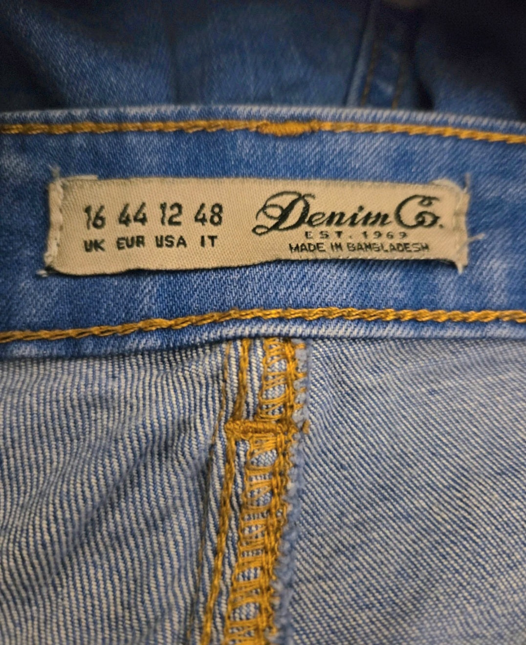 Close-up of a denim label on a blue denim fabric with 'Denim Co.' branding.