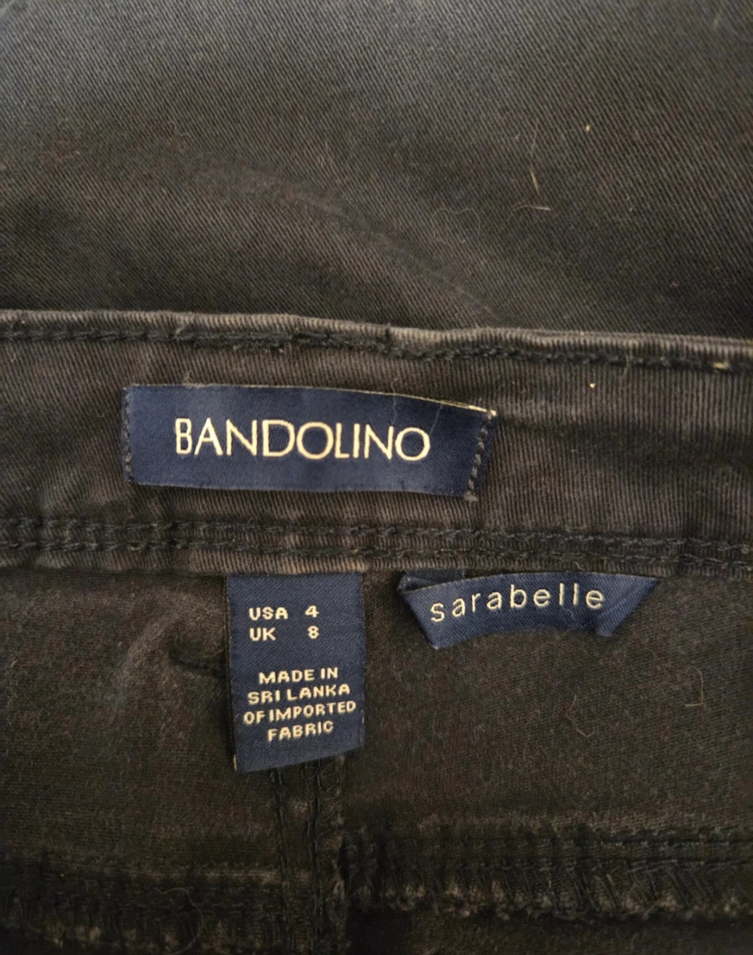 Close-up of Bandolino and sarabelle labels on dark fabric.