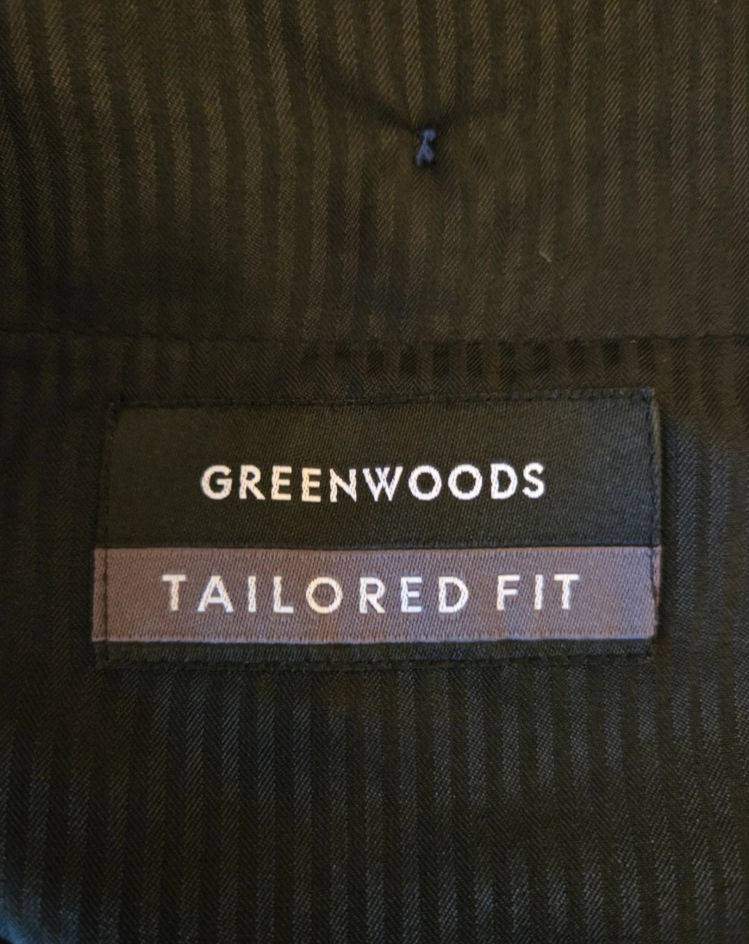 Greenwoods Tailored Fit label on a dark fabric background