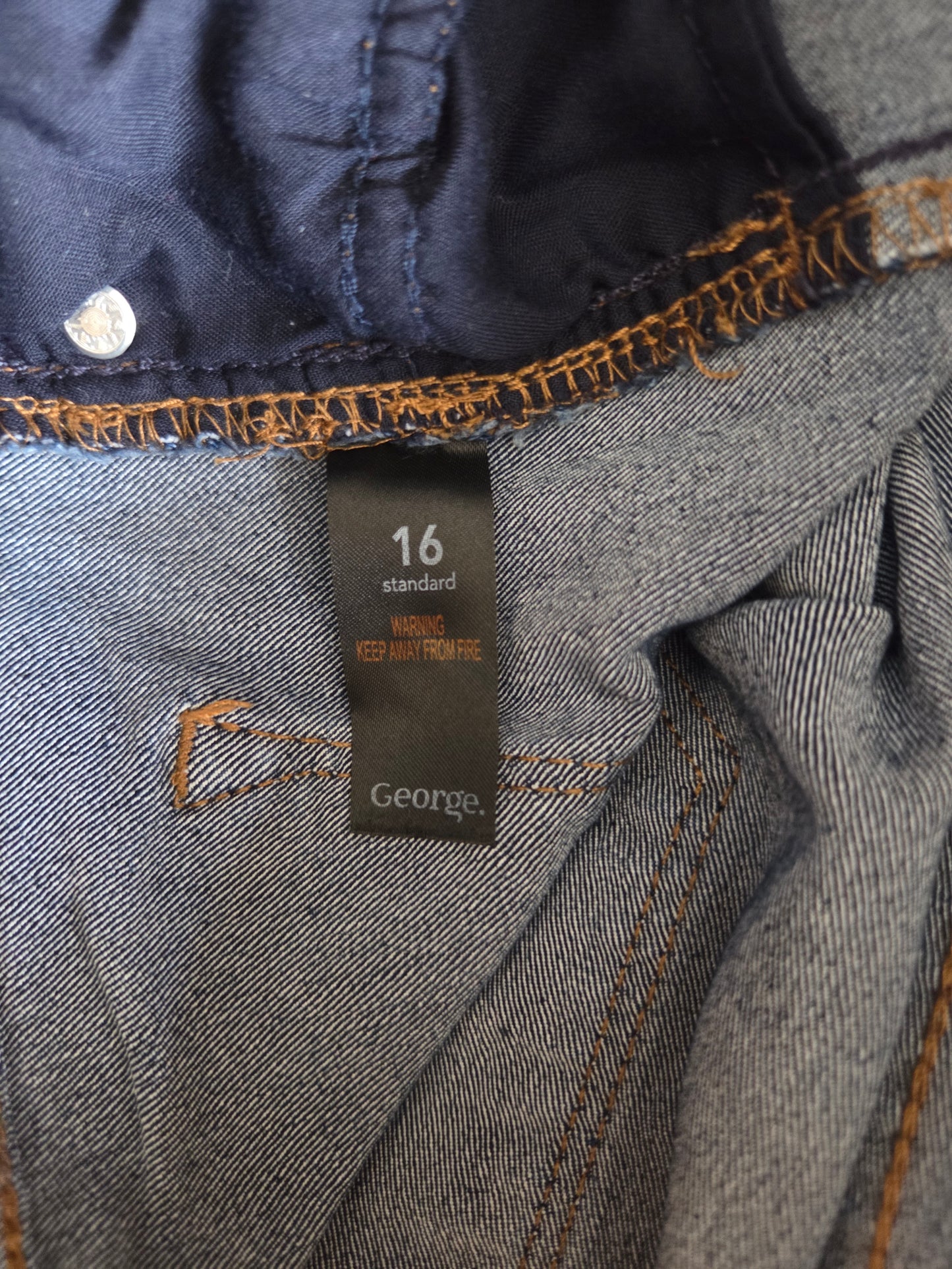 Close-up of a denim fabric with a brand label on a dark background