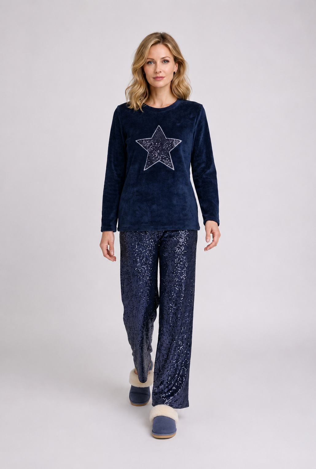 Woman wearing a navy blue pyjama set with a star design 