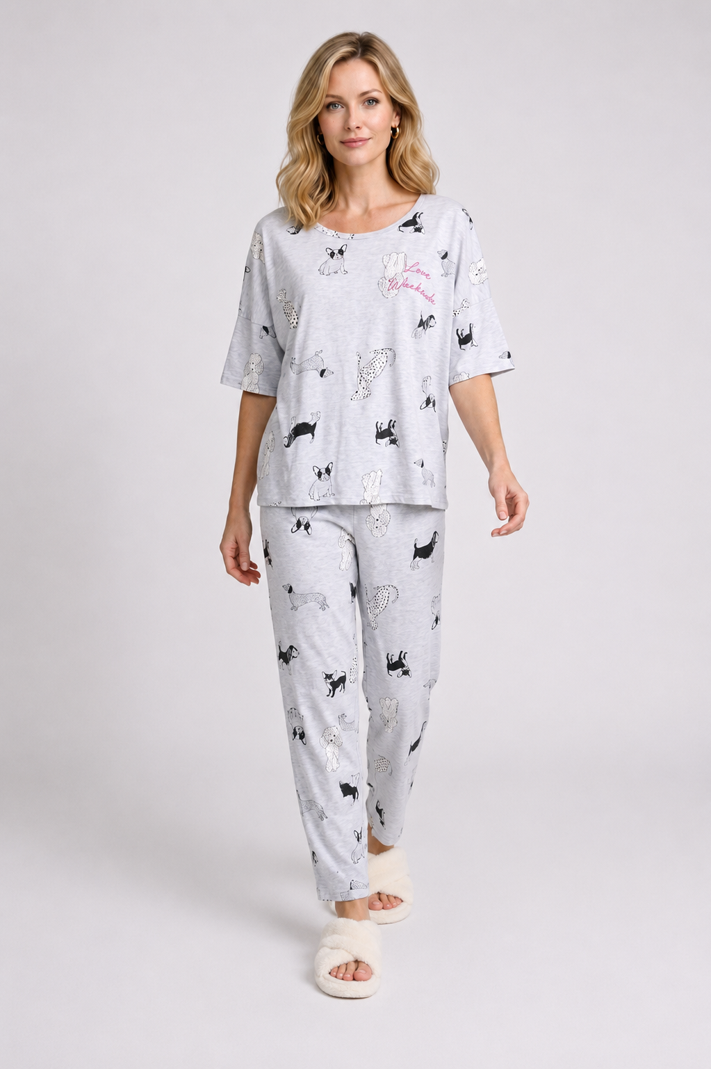 Woman wearing a white pajama set with black dog prints 