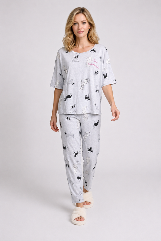 Woman wearing a white pajama set with black dog prints 