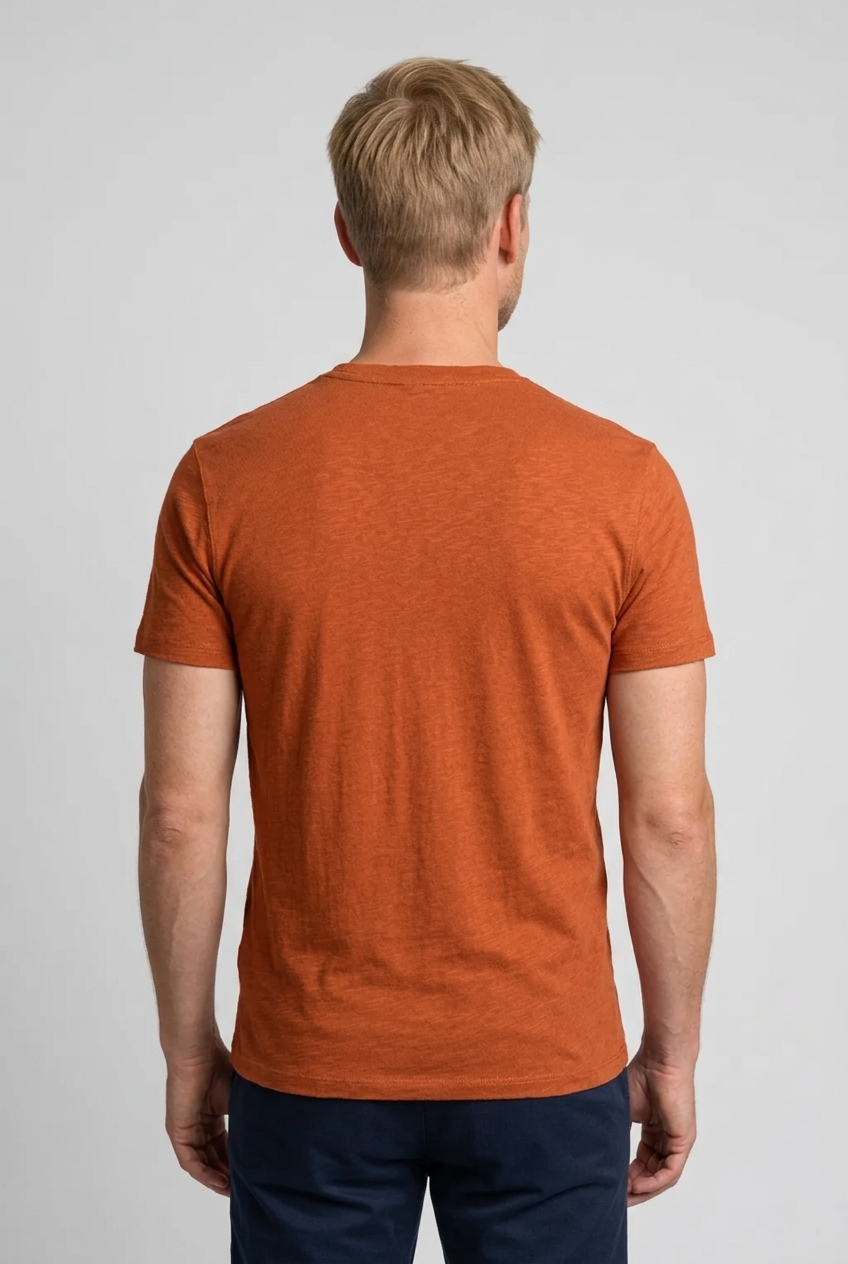 Man wearing an orange t-shirt on a plain background
