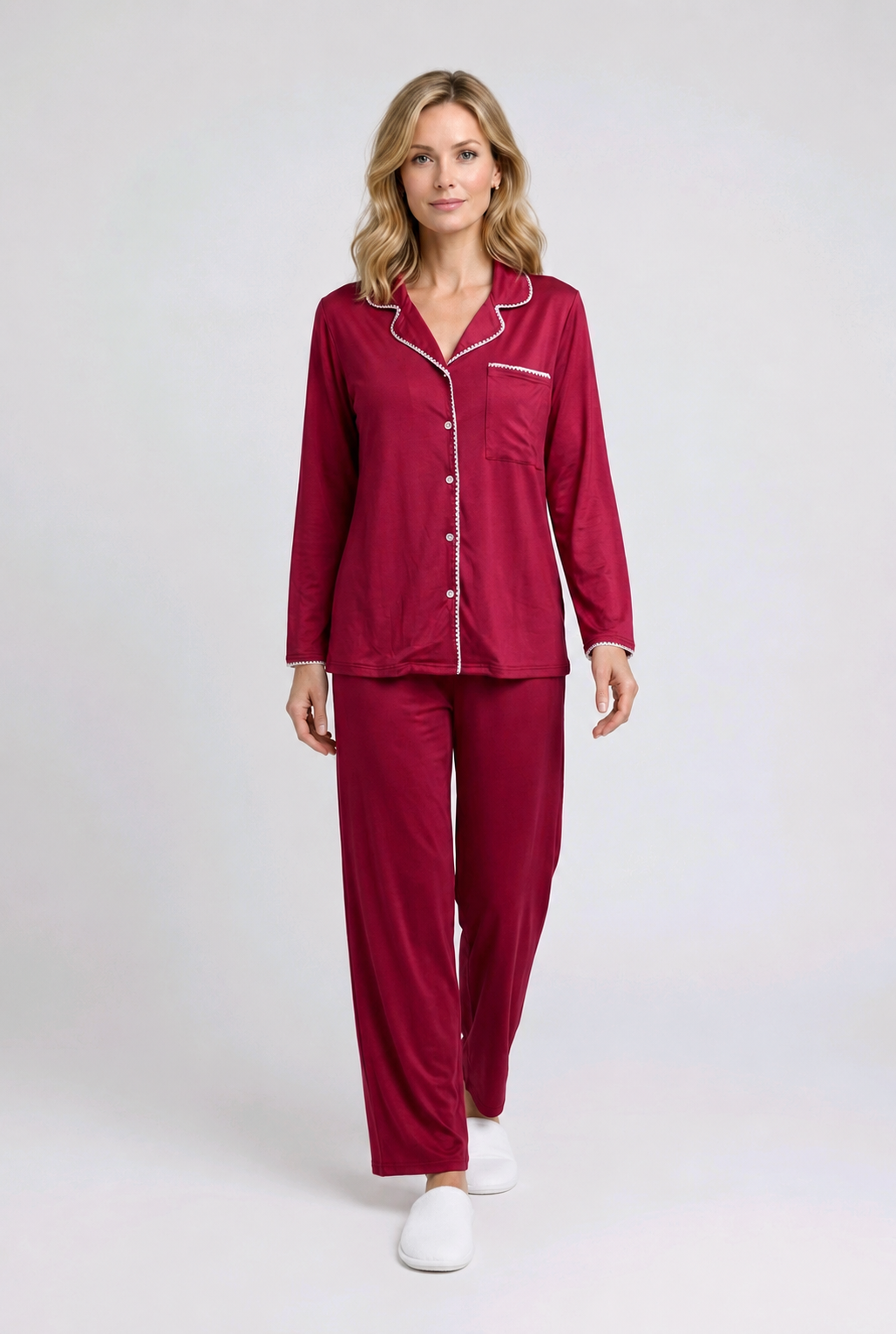 Woman wearing a burgundy pajama set with white buttons 