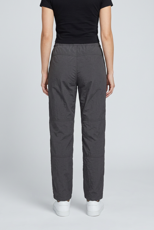 Woman wearing grey reebok track pants and a black top back view